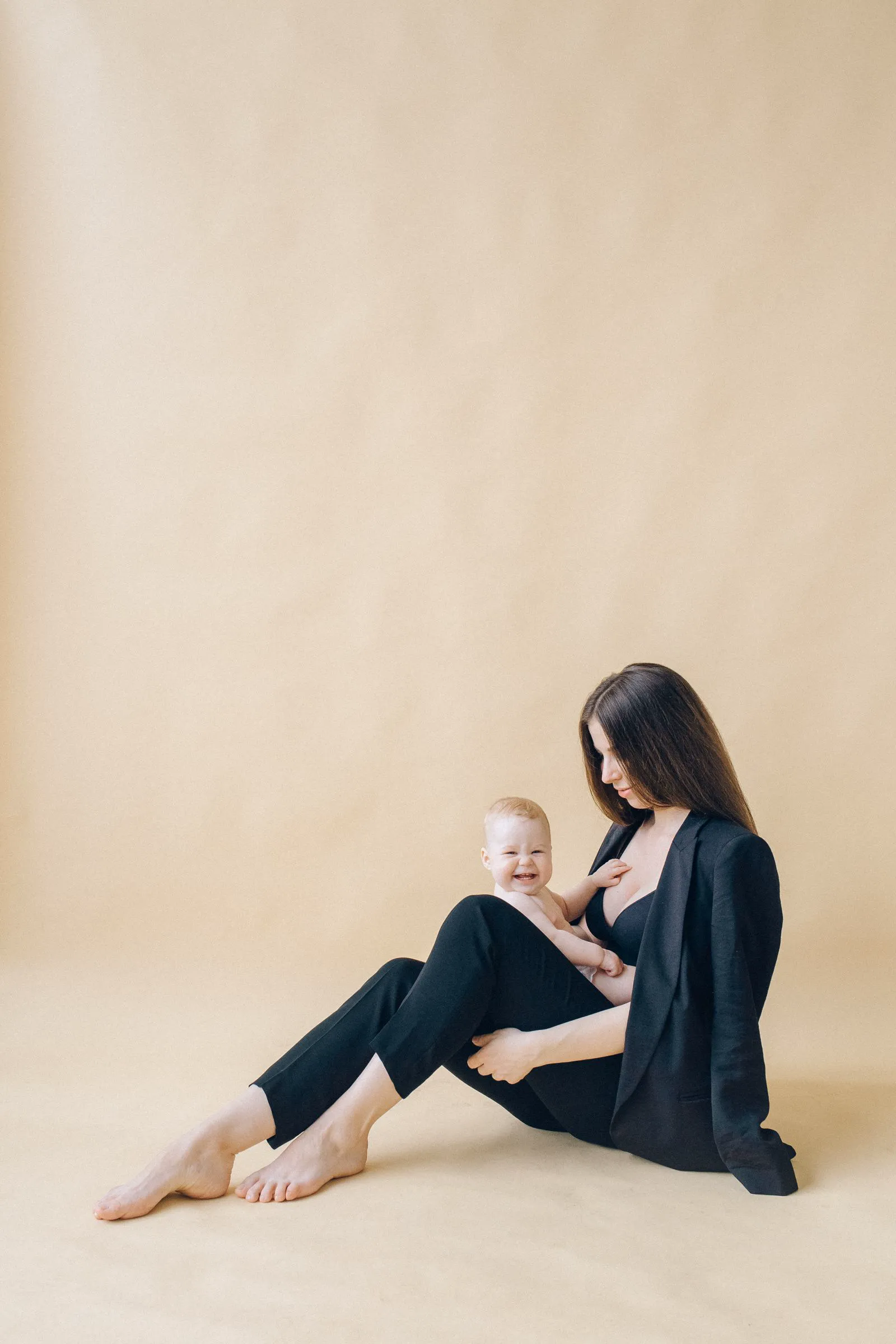 Mãe segurando o bebê em estúdio minimalista
