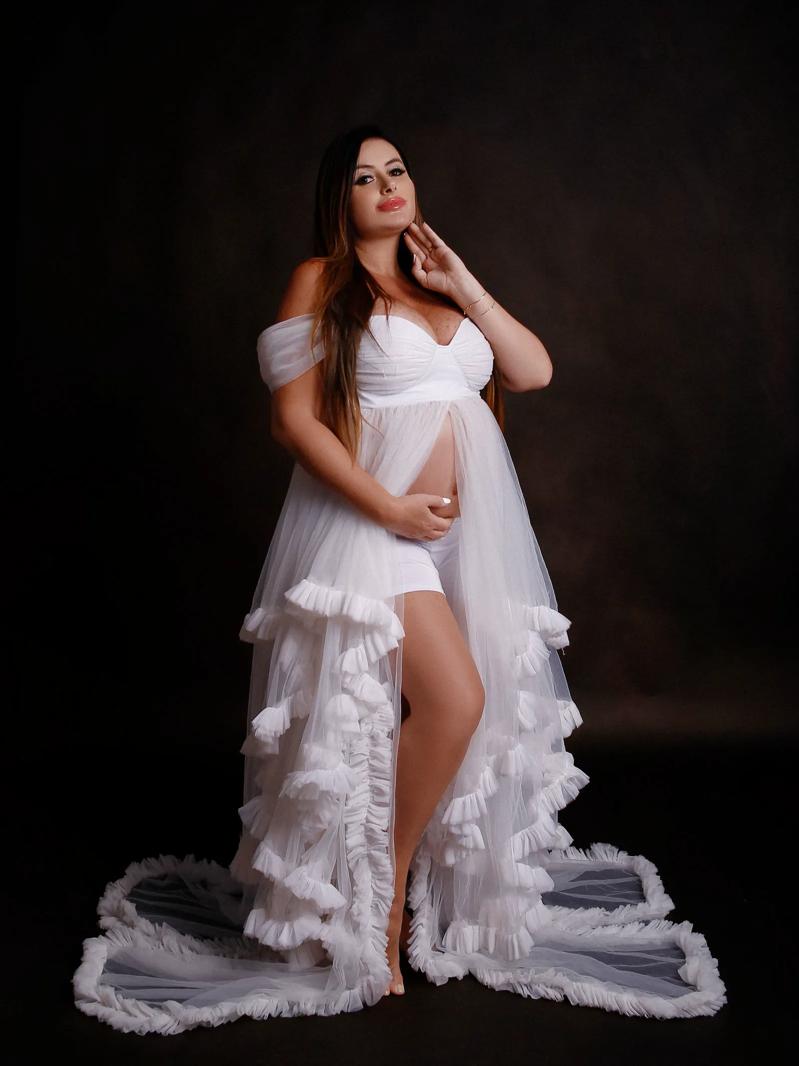 Gestante com vestido fluido branco em estúdio